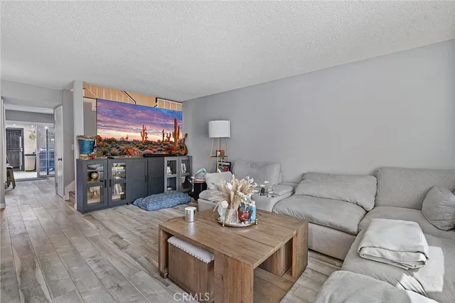 a living room with furniture a flat screen tv and a dining table with wooden floor