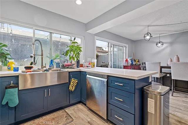 a kitchen with kitchen island granite countertop a sink cabinets and wooden floor