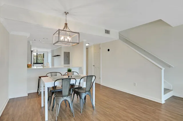 a living room with furniture large window and wooden floor