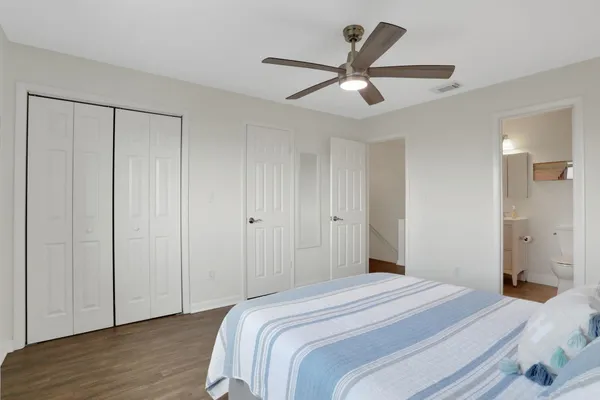 a view of a bedroom with a bed and wooden floor
