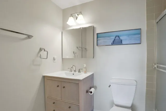 a bathroom with a toilet a sink a mirror and vanity