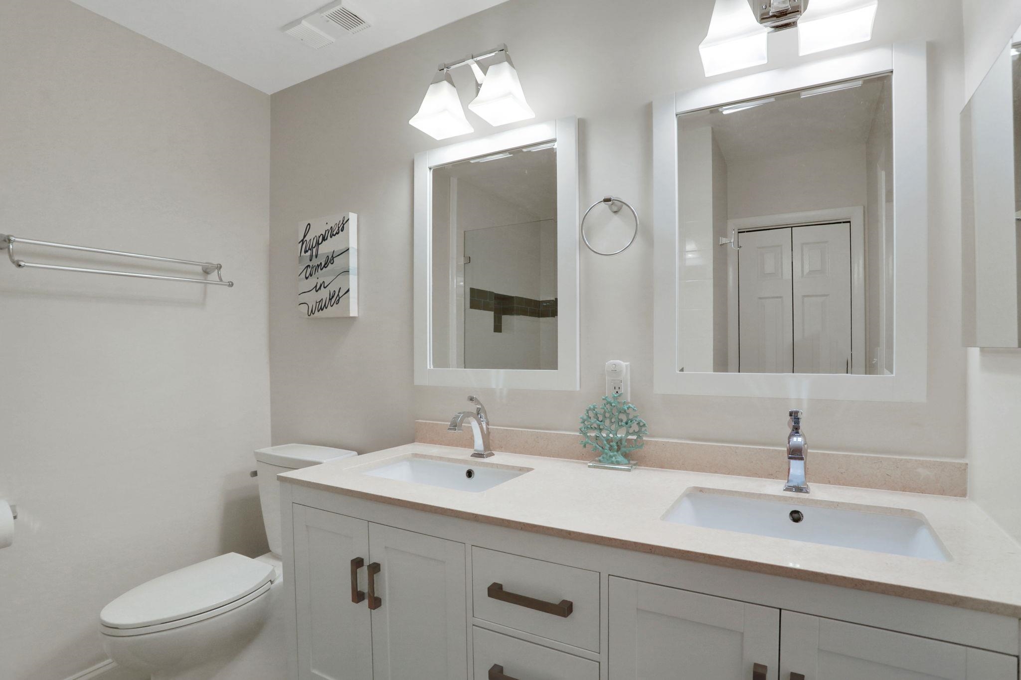 120 Sunset Harbor Way, Unit 202 St. Augustine, FL 32080 - Photo 31 of 50 a bathroom with a toilet a sink a mirror and vanity