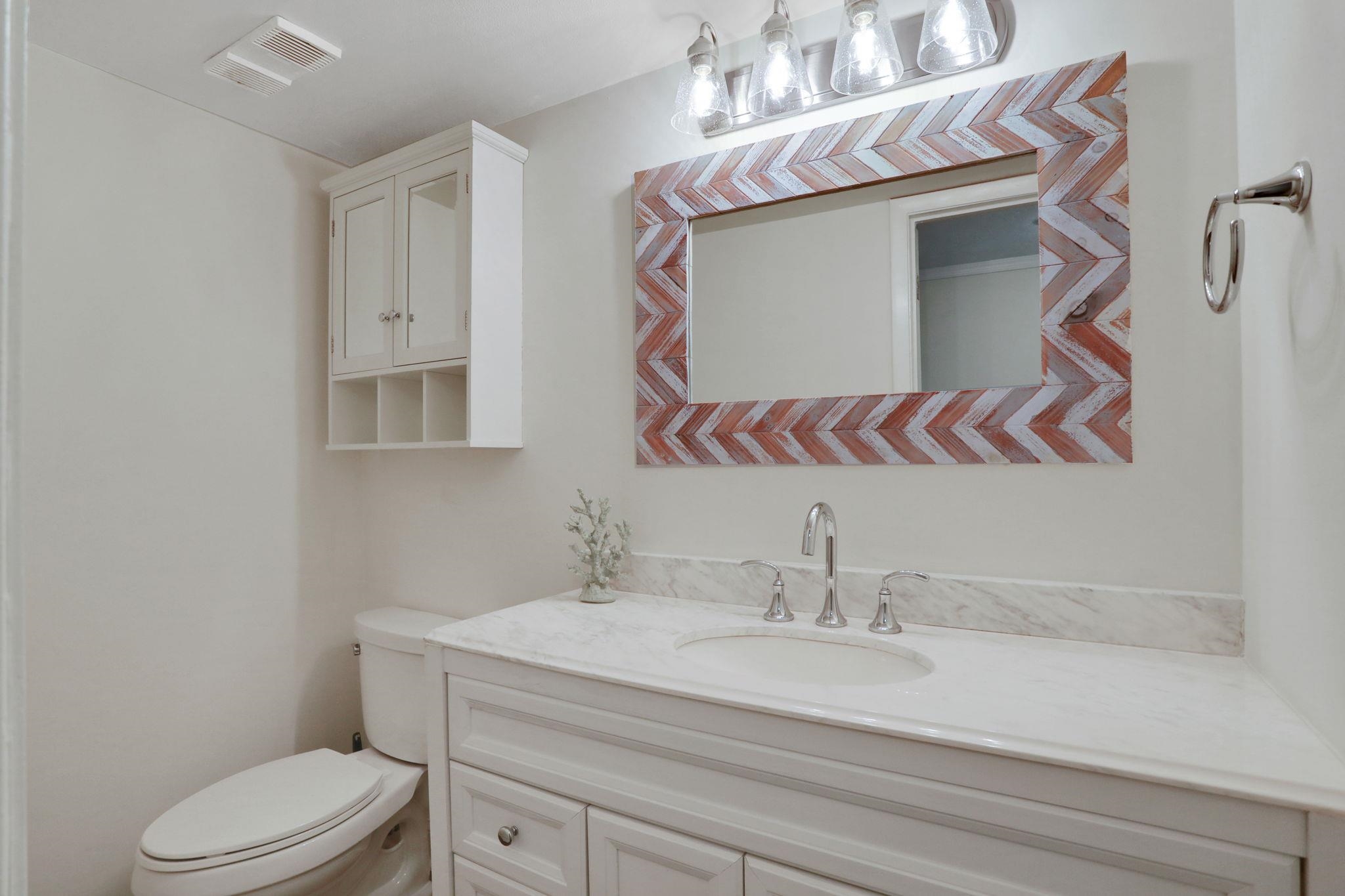 120 Sunset Harbor Way, Unit 202 St. Augustine, FL 32080 - Photo 7 of 50 a bathroom with a sink a mirror and a toilet