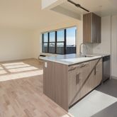 a kitchen with a stove and a wooden floor