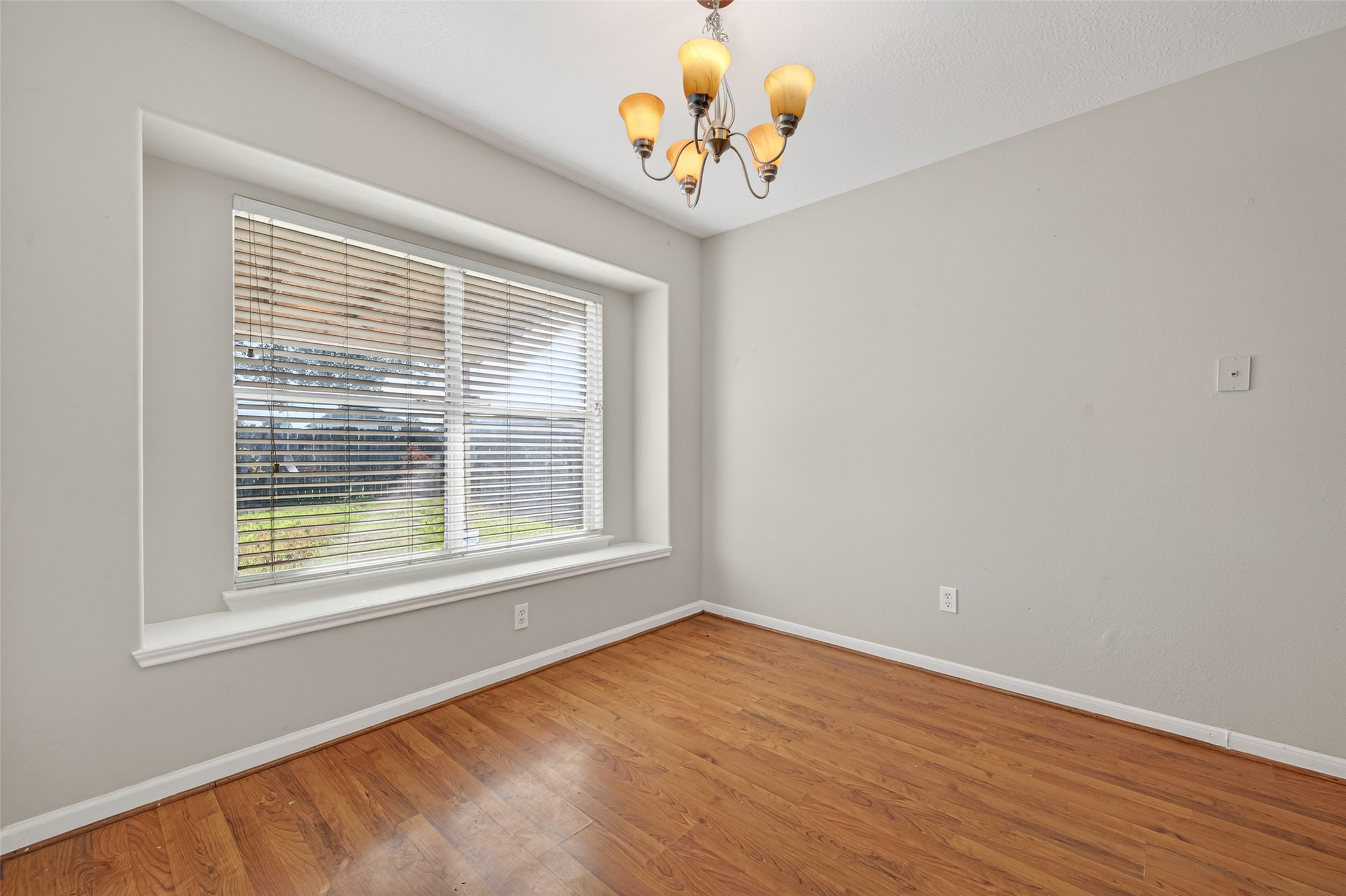 20347 Hunterclif Lane Katy, TX 77449 - Photo 12 of 39 This dining area features wood flooring, a statement light fixture, and a large window for natural light.