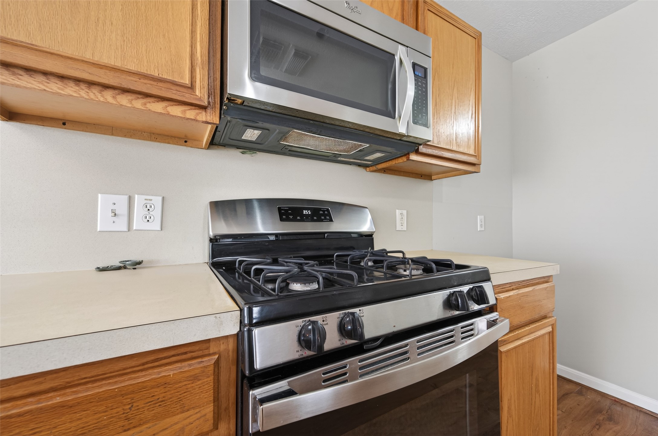 20347 Hunterclif Lane Katy, TX 77449 - Photo 15 of 39 Close-up of the cooking station featuring a stainless steel gas range, over-the-range microwave, and neutral countertops.