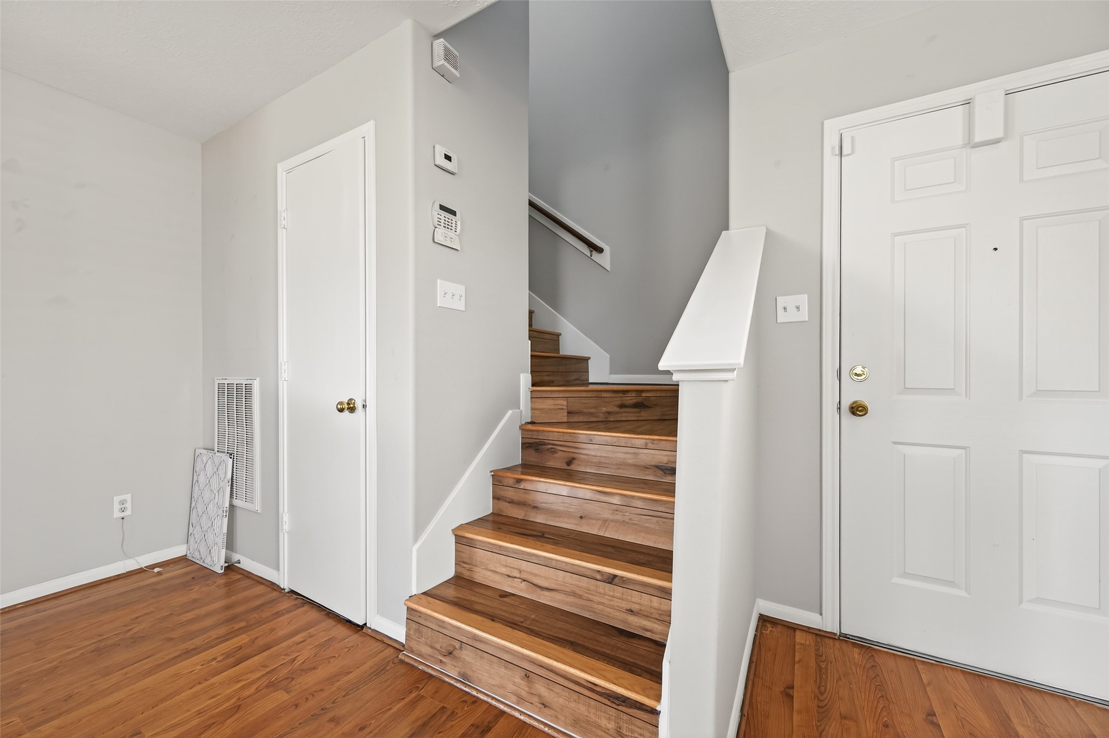 20347 Hunterclif Lane Katy, TX 77449 - Photo 20 of 39 Staircase landing view highlighting the stained wood treads, white risers, and convenient access to the entry and coat closet.
