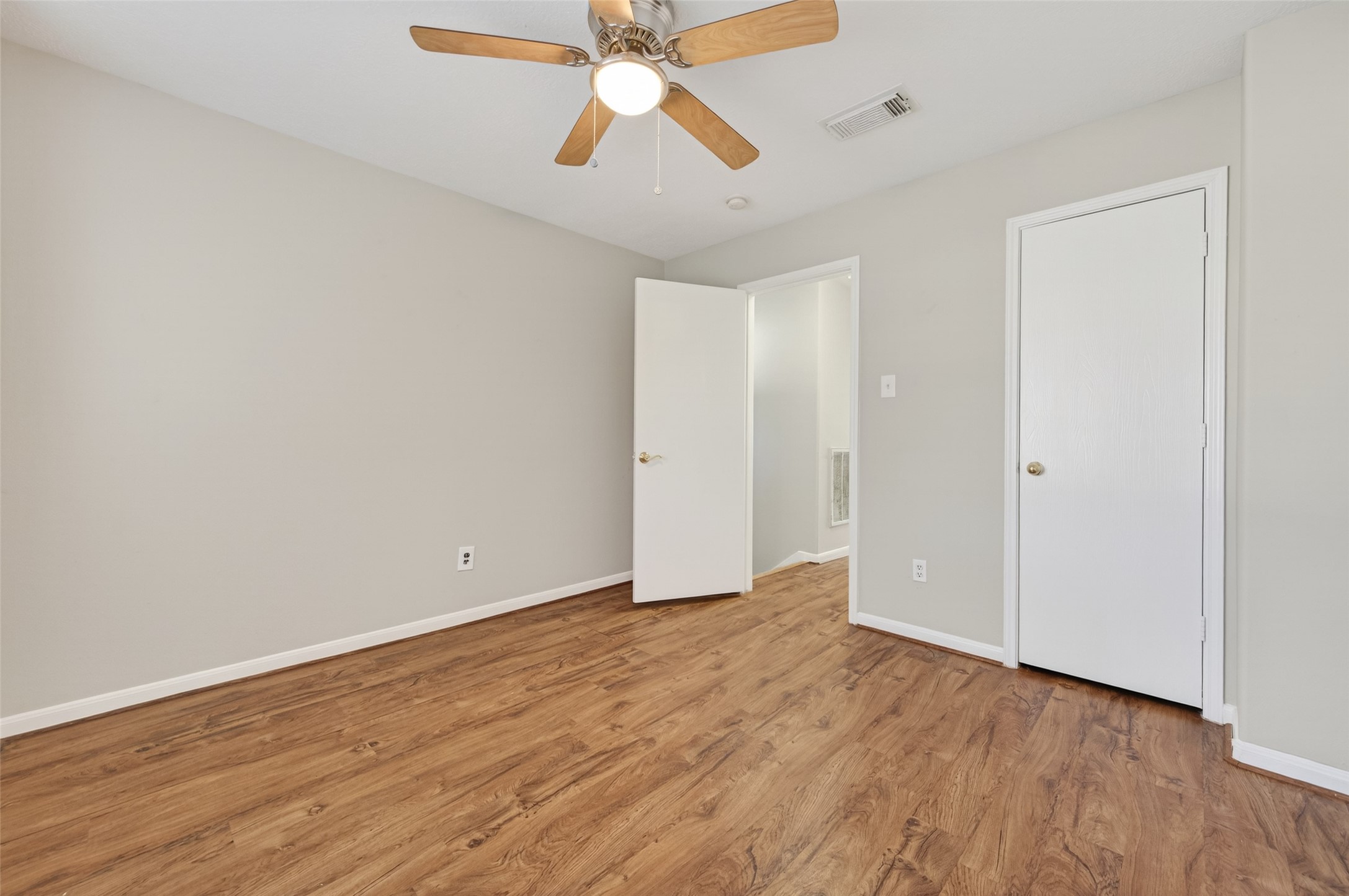 20347 Hunterclif Lane Katy, TX 77449 - Photo 29 of 39 An alternate angle shows the secondary bedroom’s wood floors, ceiling fan, and a well-organized layout.