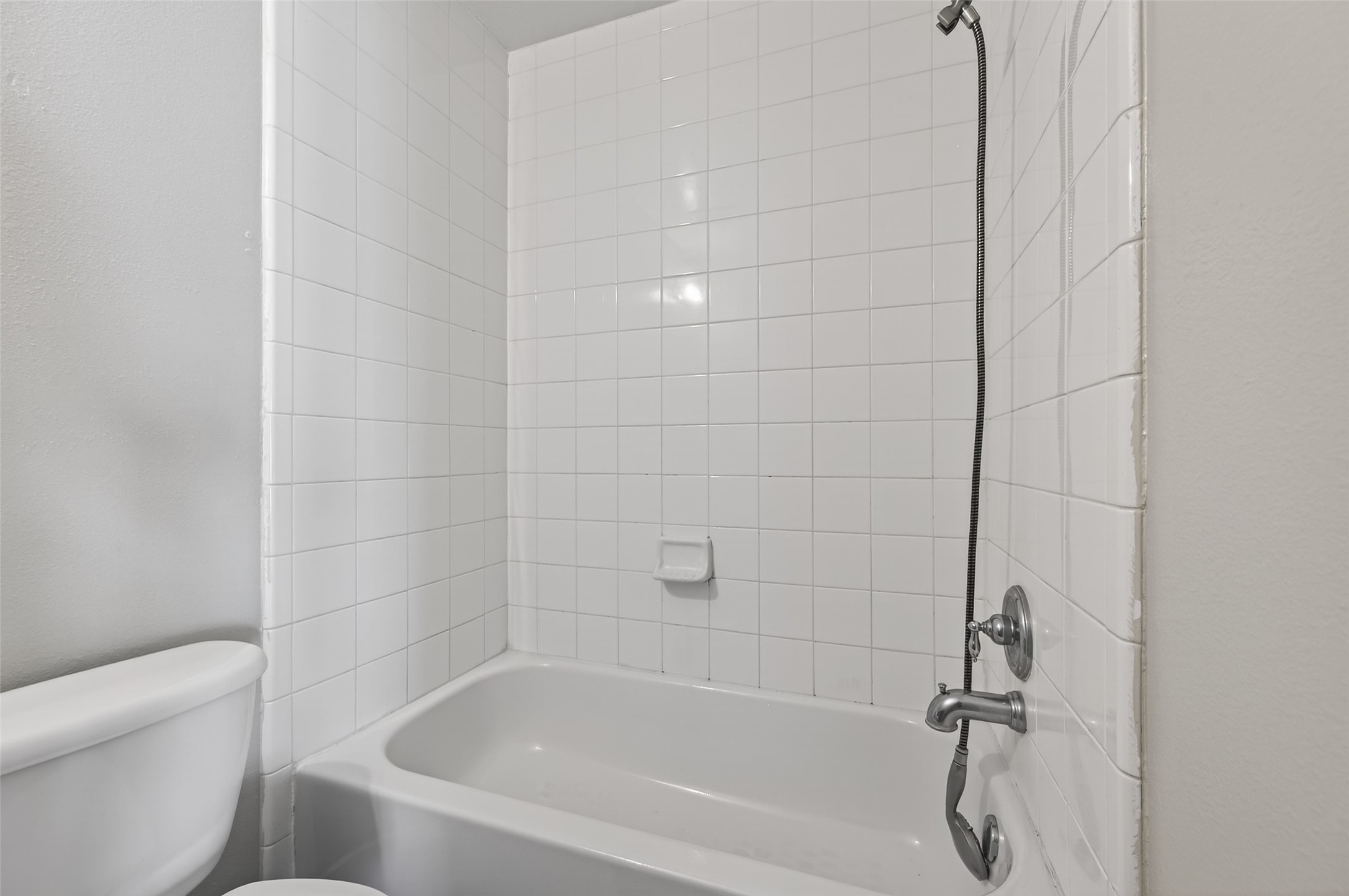 20347 Hunterclif Lane Katy, TX 77449 - Photo 31 of 39 Close-up of the bathtub area highlighting the neutral white tile surround and shower fixture