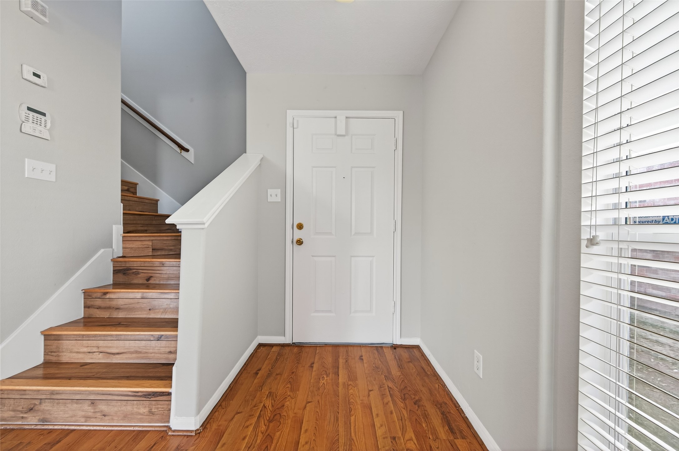 20347 Hunterclif Lane Katy, TX 77449 - Photo 7 of 39 Bright and inviting foyer featuring durable wood-look flooring and a staircase with stained wood treads and white risers.