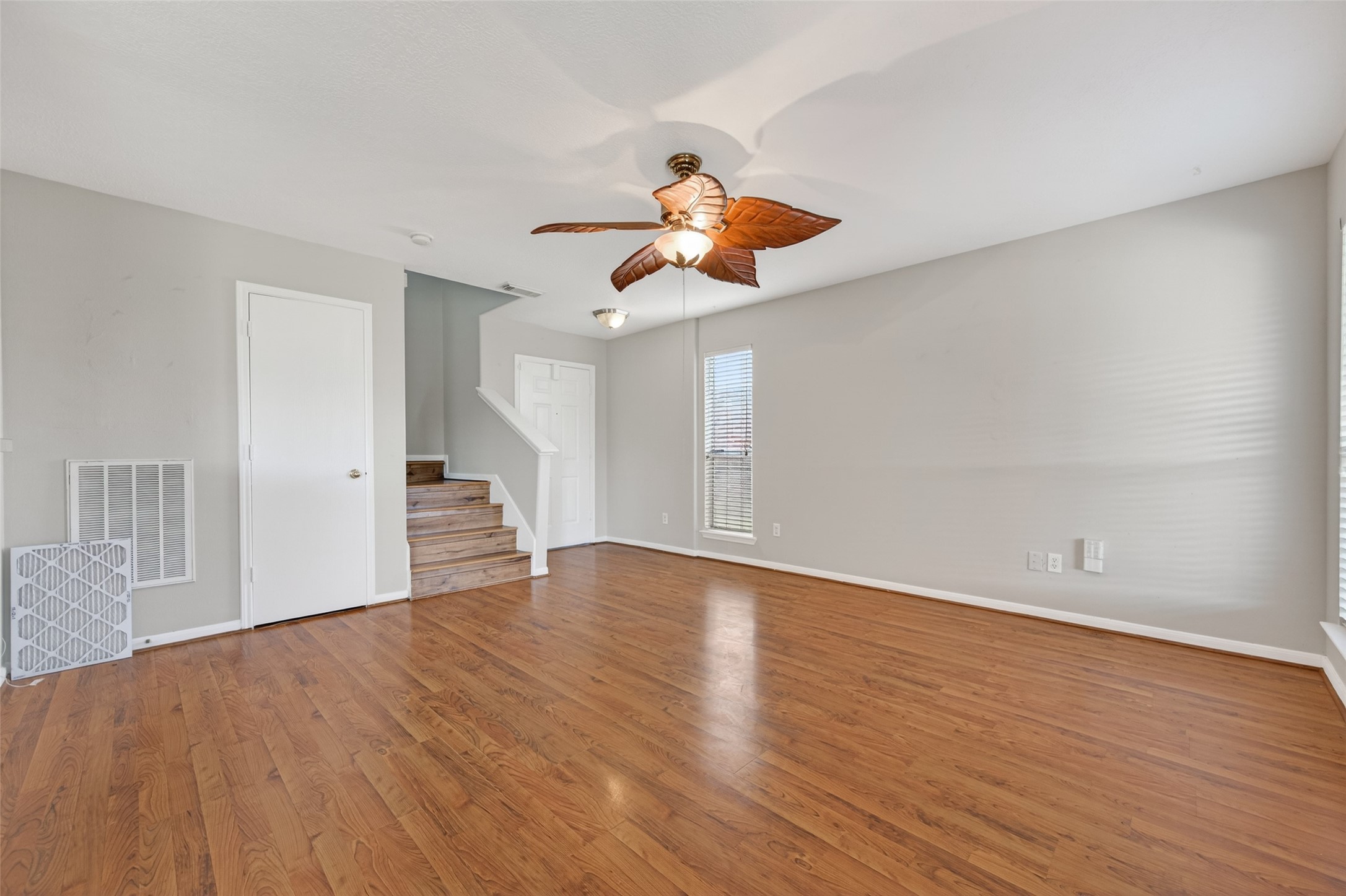 20347 Hunterclif Lane Katy, TX 77449 - Photo 9 of 39 Open-concept living space with neutral paint tones, a ceiling fan fixture, and easy flow towards the staircase and entry.