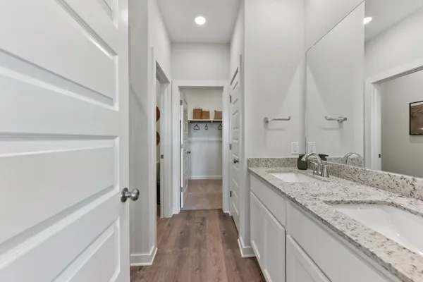 a bathroom with a granite countertop double vanity sink and mirror