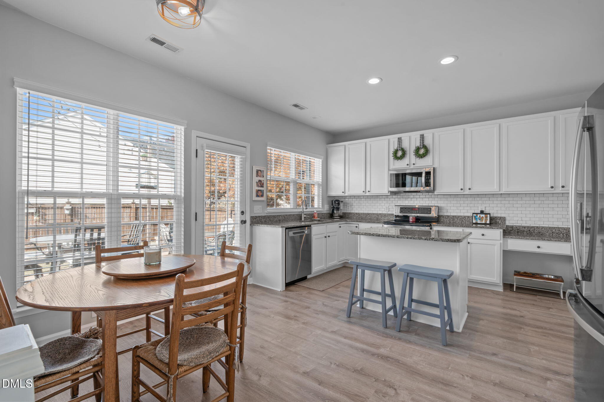 7461 Lagrange Drive Raleigh, NC 27613 - Photo 17 of 54 a kitchen with a dining table chairs and refrigerator
