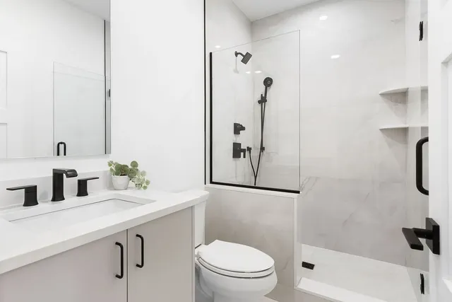 a bathroom with a sink a toilet and shower