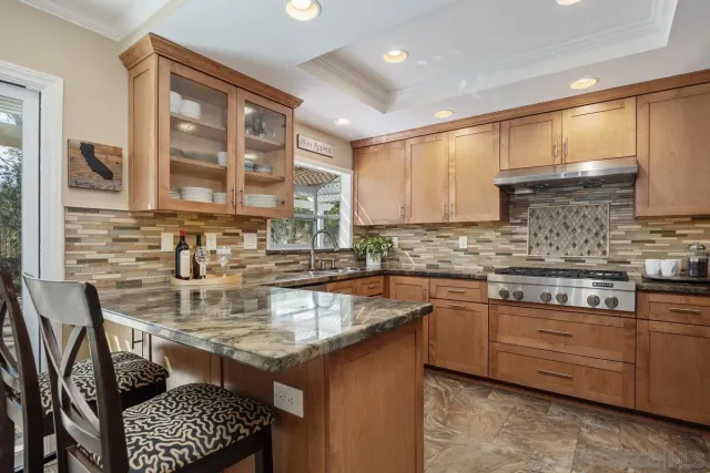 a kitchen with stainless steel appliances granite countertop a stove sink and cabinets