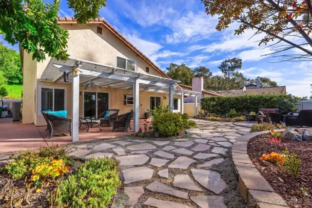 a view of a house with backyard sitting area and tub
