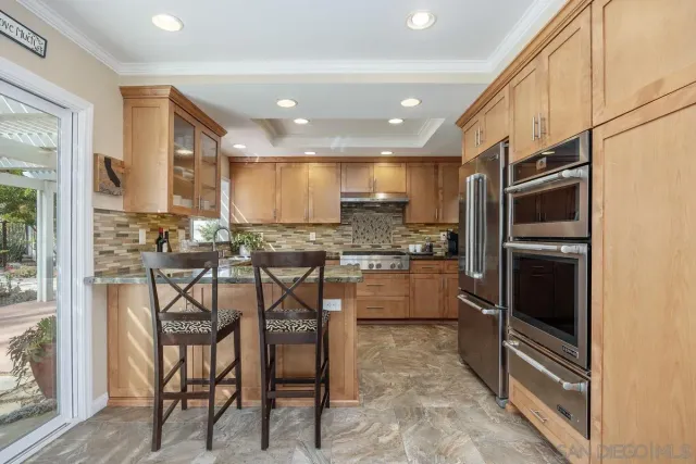 a kitchen with stainless steel appliances granite countertop a sink stove and cabinets