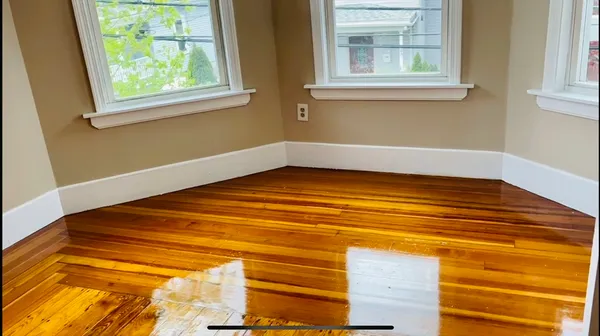 a view of a room with wooden floor and a window