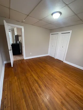 a view of empty room with wooden floor