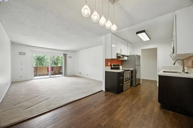 a kitchen with kitchen island granite countertop a stove and a wooden floors