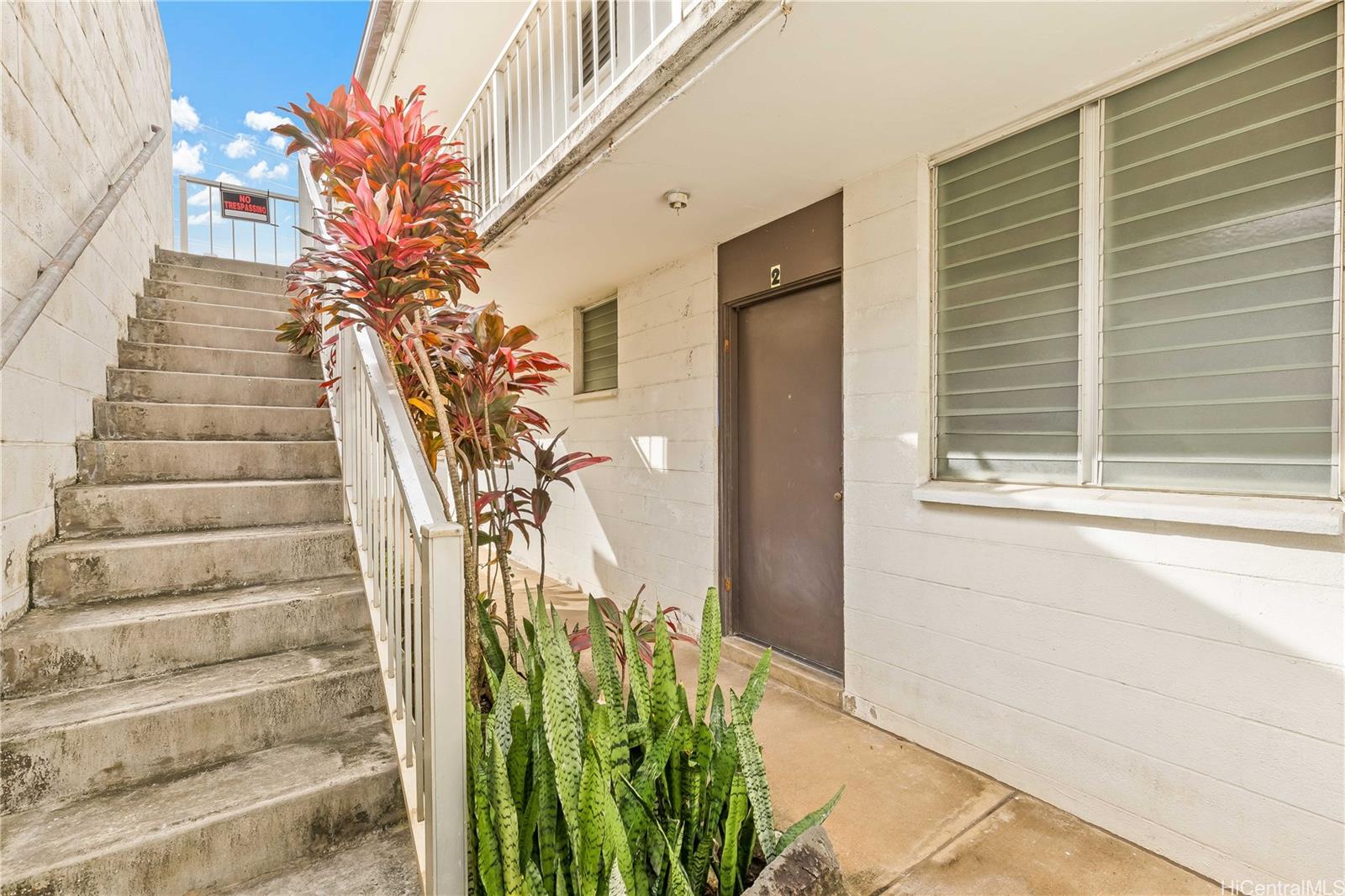 910 Factory Street Honolulu, HI 96819 - Photo 9 of 19 a vase of flowers sitting on a floor in front of a door
