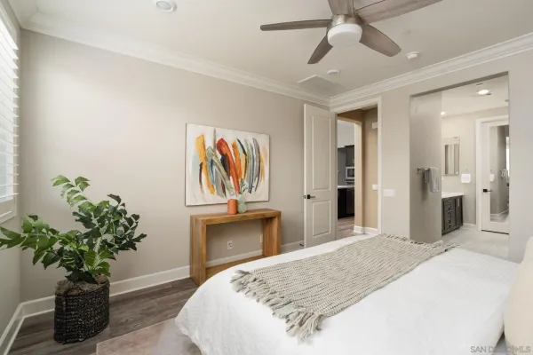 a bedroom with a bed and a potted plant
