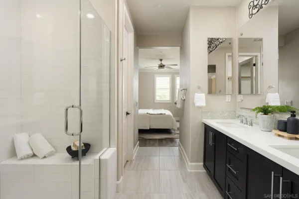a en suite bathroom with a shower sink and mirror
