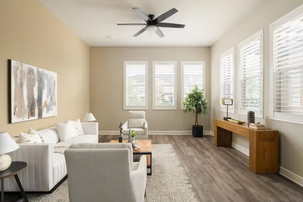 a living room with furniture large window and wooden floor