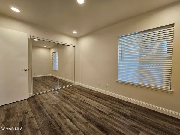 a view of empty room with wooden floor and fireplace