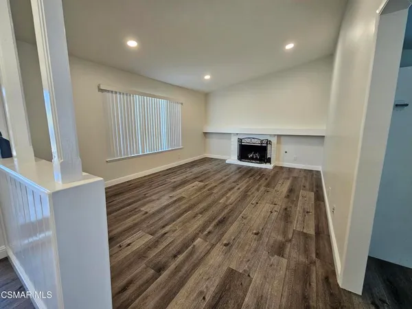 a kitchen with stainless steel appliances granite countertop a refrigerator a sink dishwasher a stove and white countertops with wooden floor