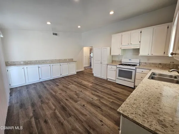 a kitchen with stove cabinets and wooden floor