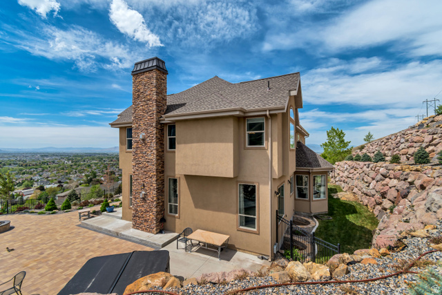 2543 East 700 South Springville, UT 84663 - Photo 10 of 73 Back of house featuring a fenced backyard, stucco siding, roof with shingles, and a chimney