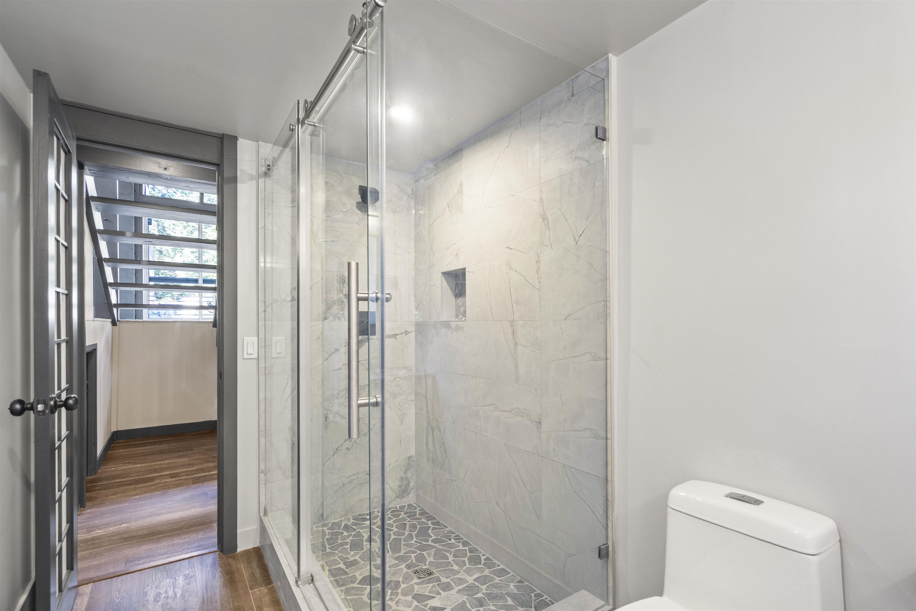 2570 Old Mammoth Road Mammoth Lakes, CA 93546 - Photo 25 of 39 Glass-enclosed shower with a sliding barn door system, pebble stone flooring, and large format wall tile