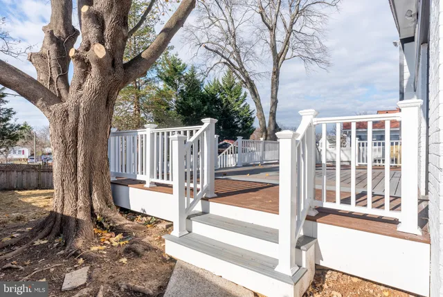 a view of a house with a large tree and wooden fence