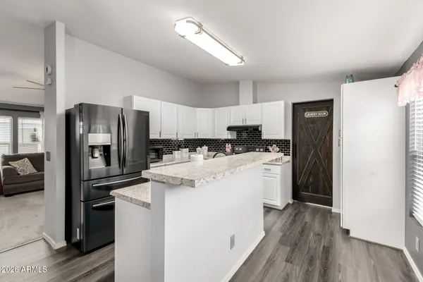 a kitchen with a refrigerator a stove top oven a sink and a hard wood floor