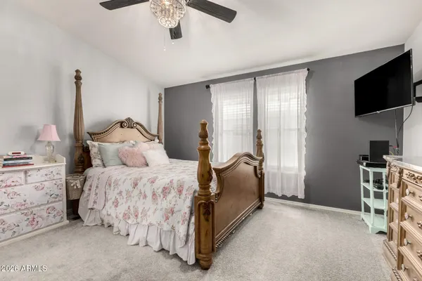 a spacious bedroom with a bed and a flat screen tv