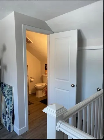 a view of a hallway with toilet and a window