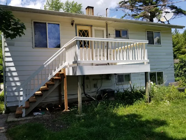 a view of a house with wooden stairs and a small yard