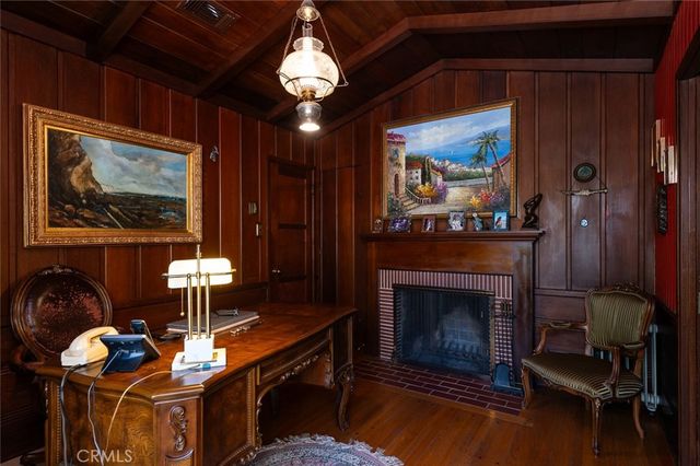 a bedroom with a bed a mirror and a flat tv screen on a dresser