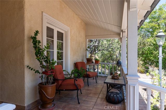 a view of a porch with chairs and potted plants