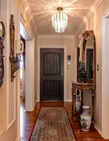 a view of a hallway with wooden floor and a chandelier