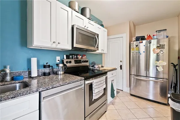 a kitchen with granite countertop stainless steel appliances and white cabinets