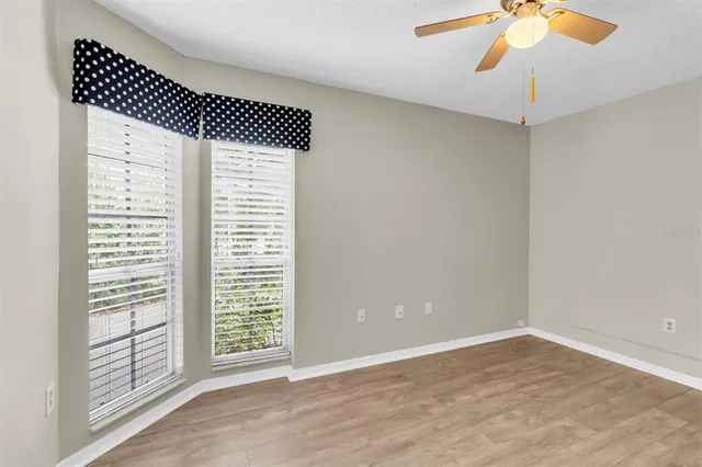 a view of empty room with a window and ceiling fan