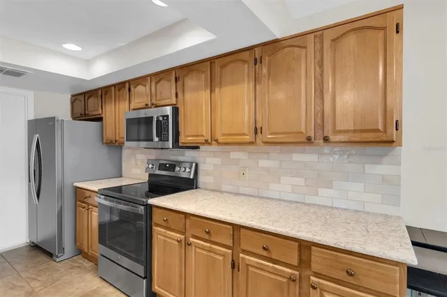 a kitchen with stainless steel appliances granite countertop a refrigerator a stove a sink and dishwasher