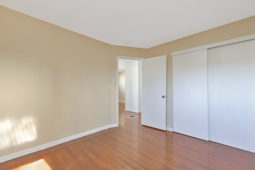 51 Broadleaf Lane Enfield, CT 06082 - Photo 21 of 36 a view of an empty room and window with wooden floor