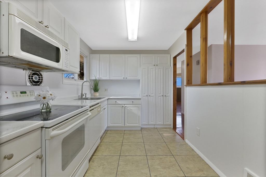 51 Broadleaf Lane Enfield, CT 06082 - Photo 5 of 36 a kitchen with a sink a microwave and cabinets