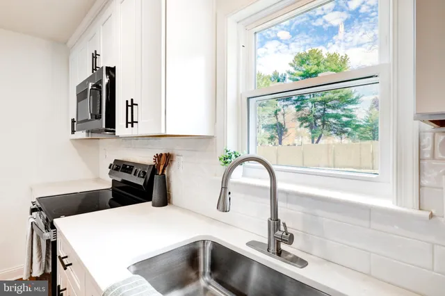 a kitchen with a sink a window and cabinets