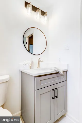 a bathroom with a sink a mirror and toilet
