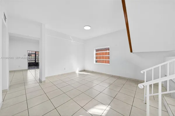 a view of an entryway with wooden floor and next to a window