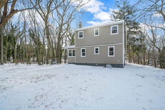 a backyard of a house with large trees and covered with wooden fence